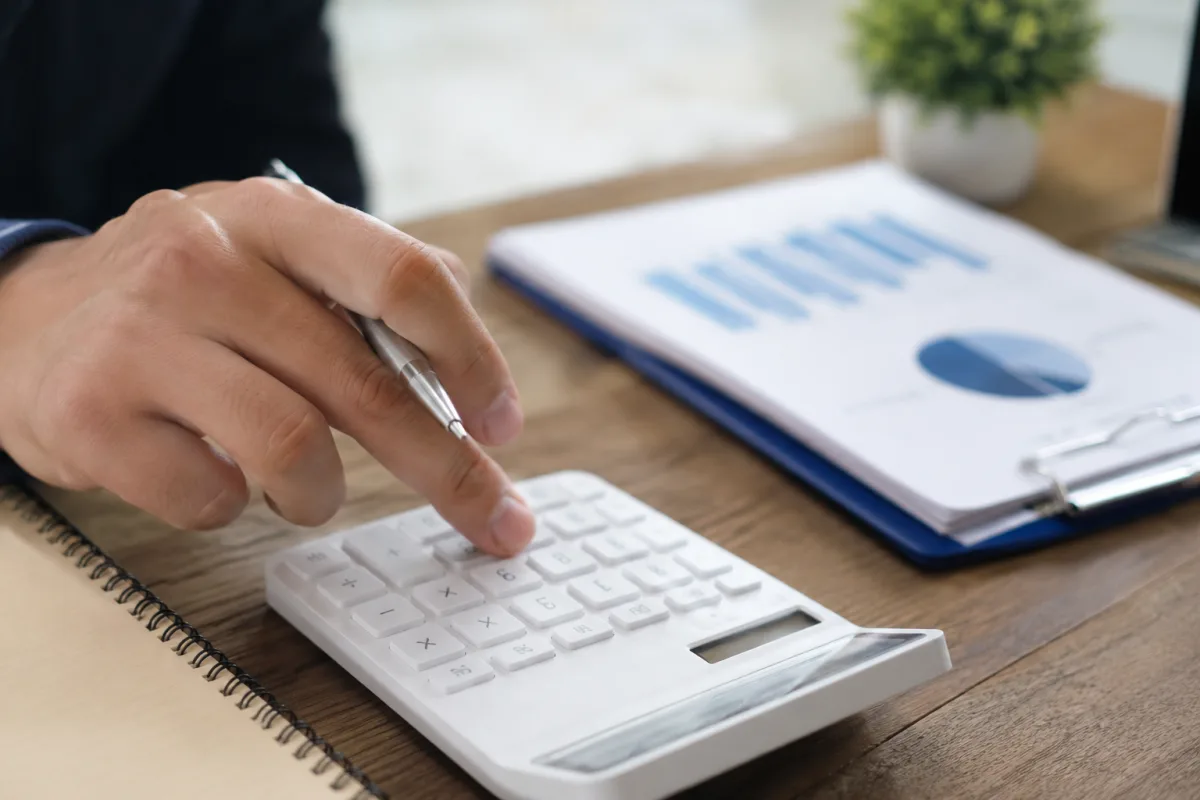 Gros plan sur un tableau comparatif de garanties santé posé sur un bureau avec un stylo et des documents de contrat d'assurance