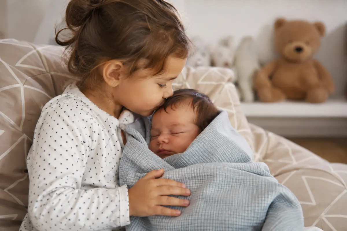 Main d'un enfant de quatre ans posée doucement sur le ventre arrondi de sa mère enceinte